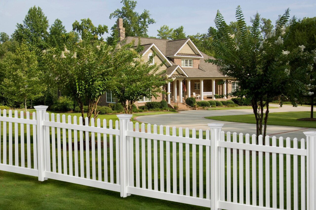 White vinyl picket fence in front of a home
