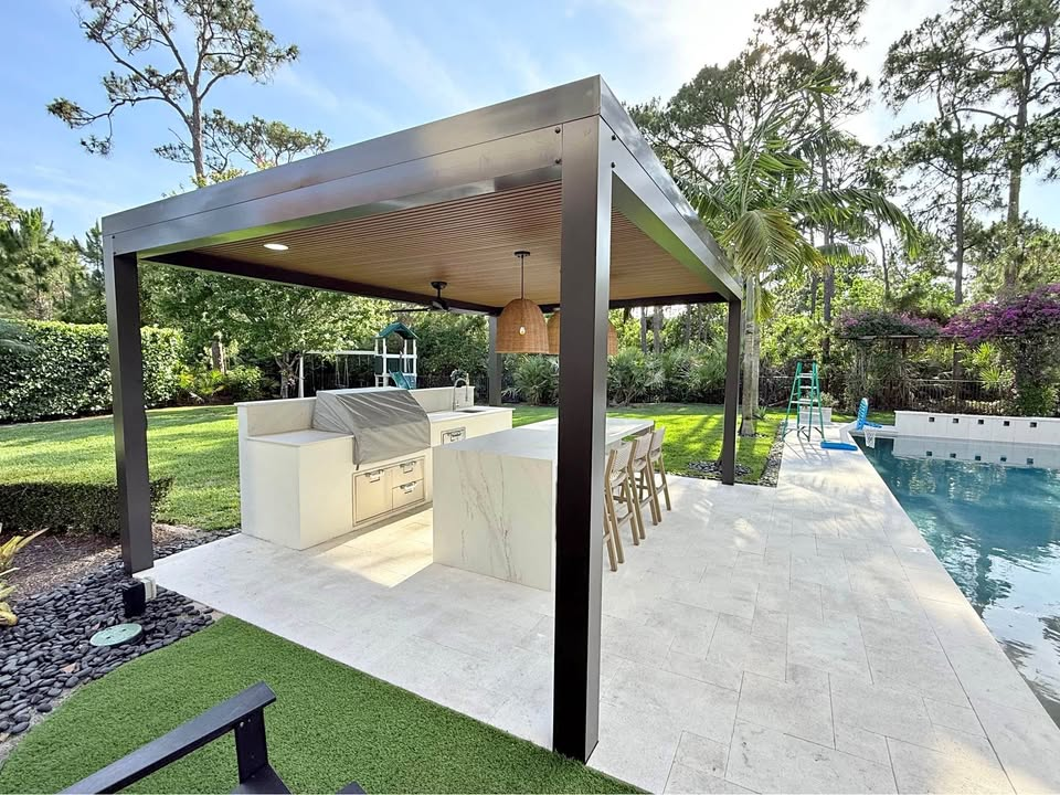 Outdoor kitchen under wood-slat pergola by the pool