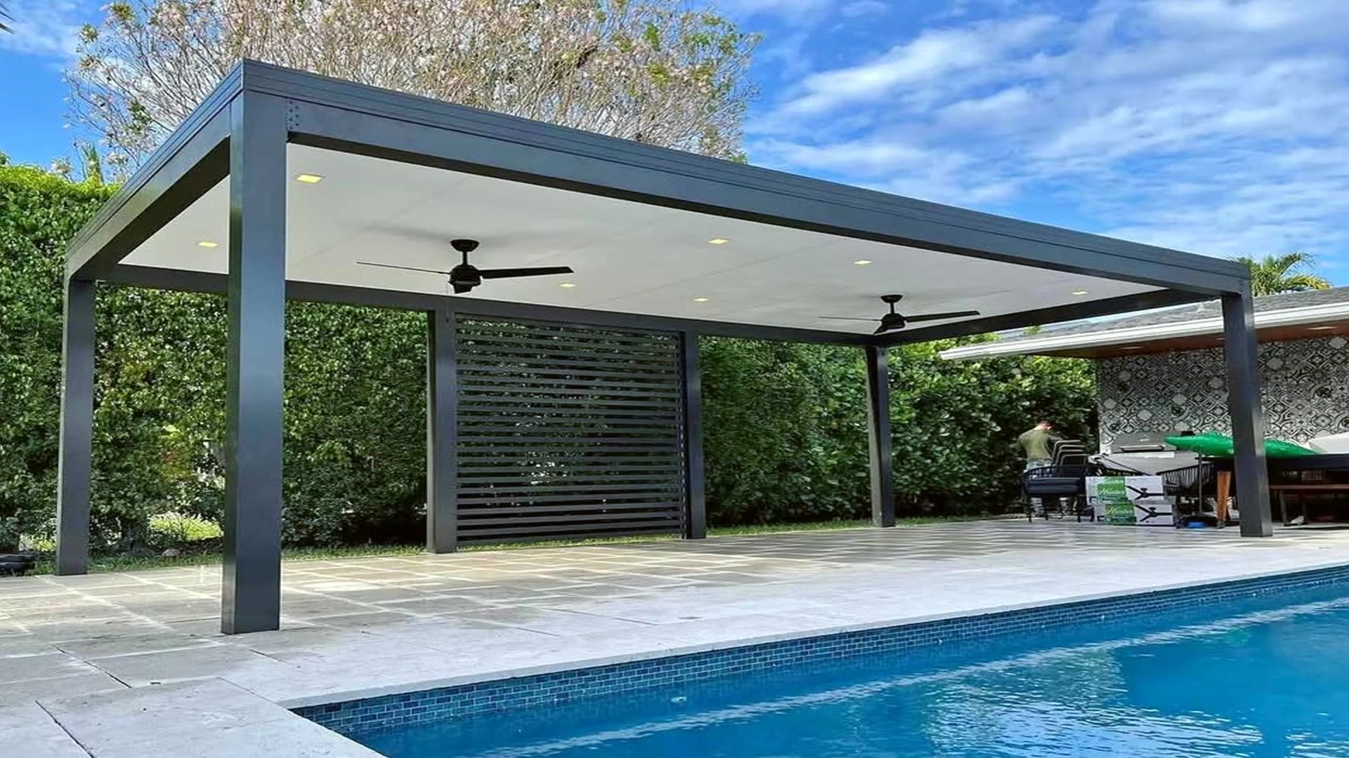 Poolside insulated pergola with fans and privacy wall in South Florida